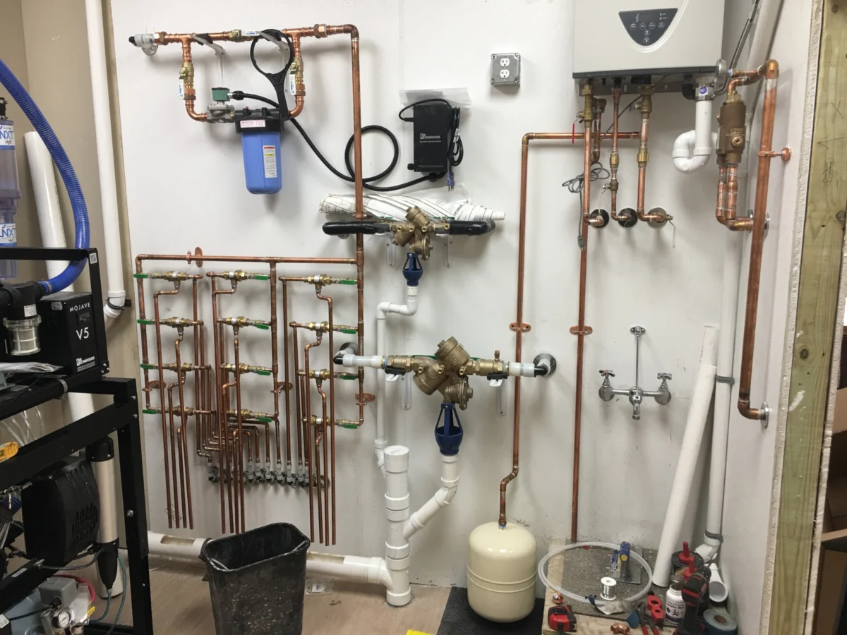 Copper and PVC piping installed on a mechanical room wall