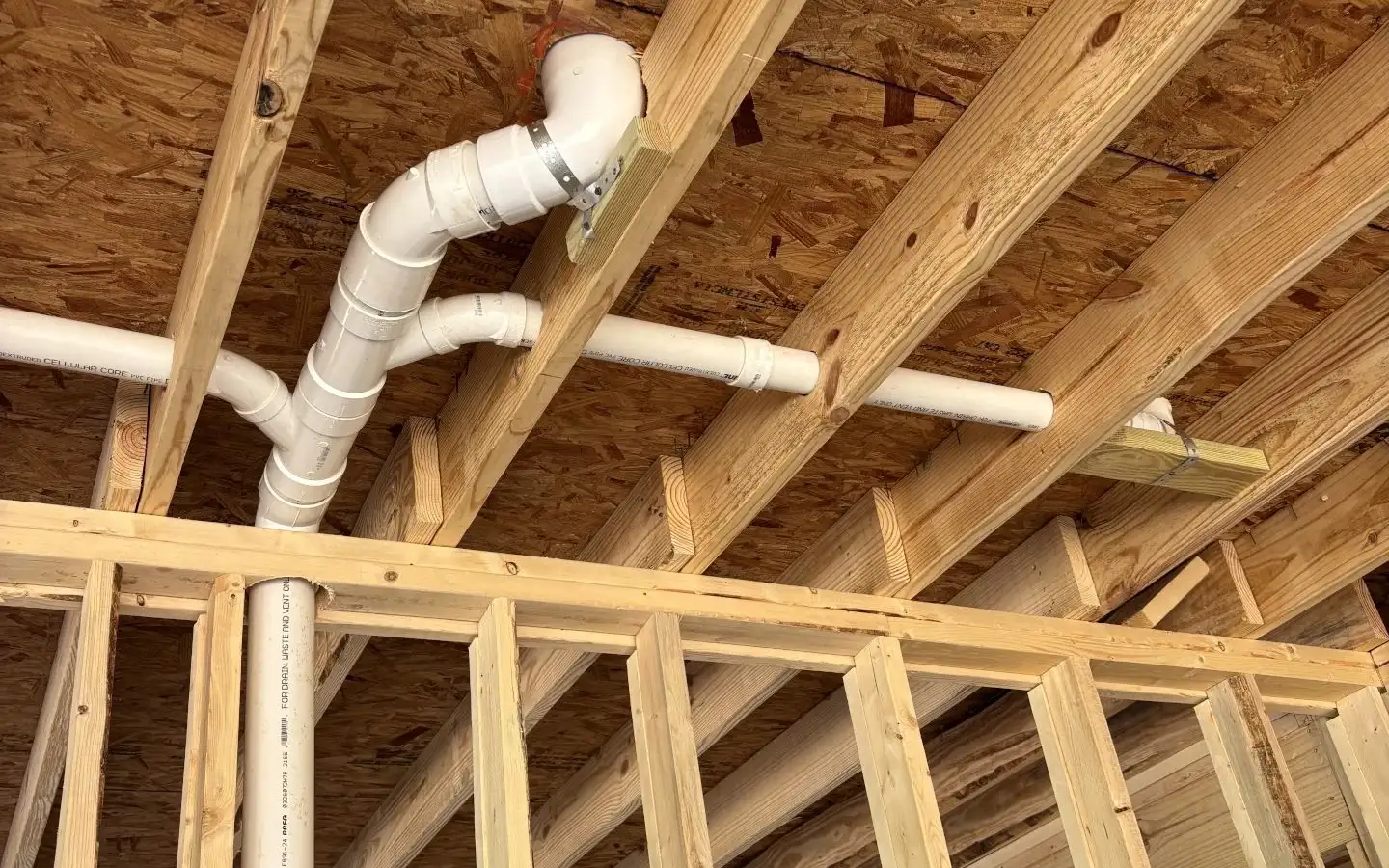 Residential rough-in plumbing in new home framing